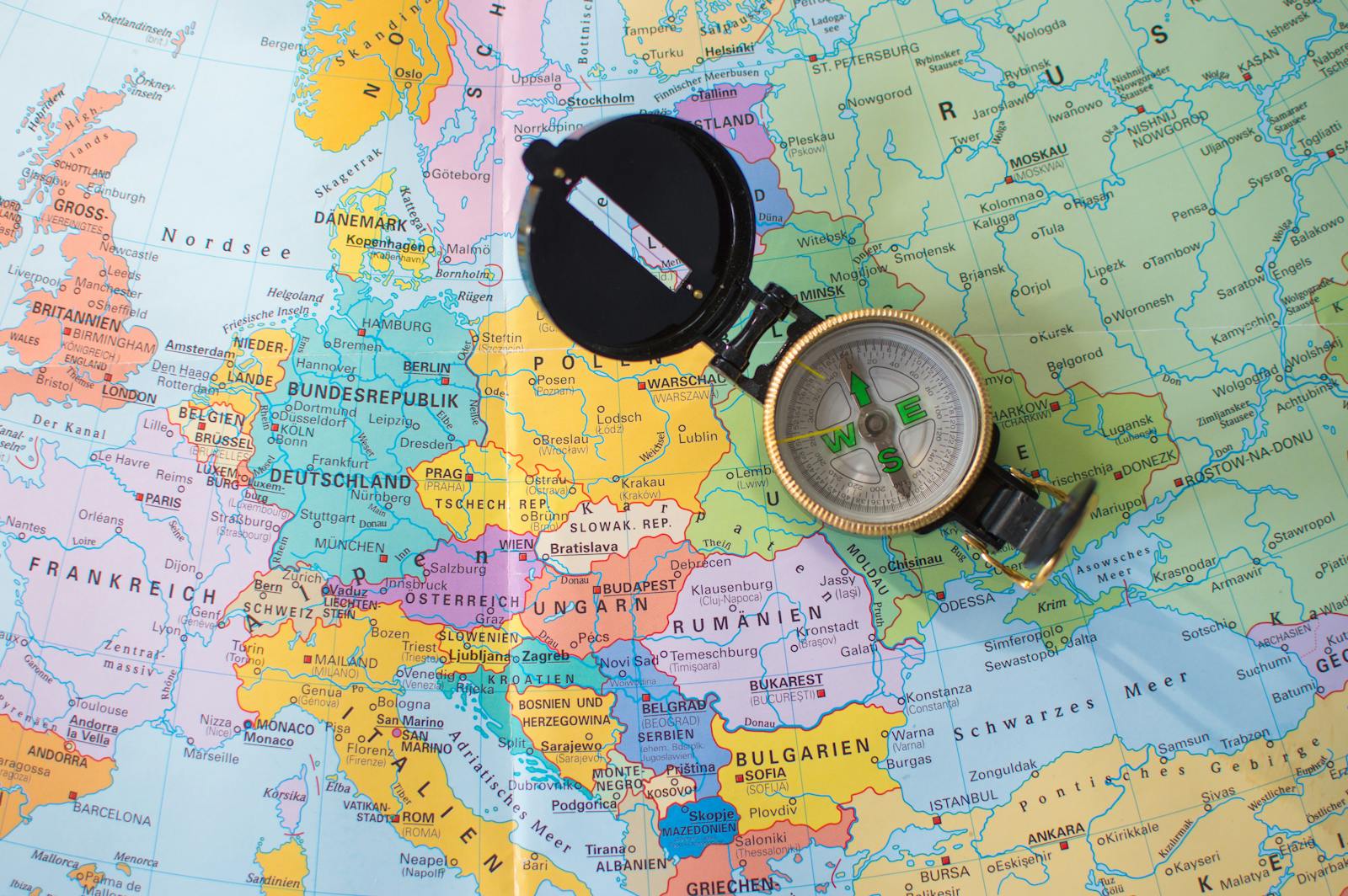 A flat lay image of a compass on a map of Europe, symbolizing travel and direction planning.